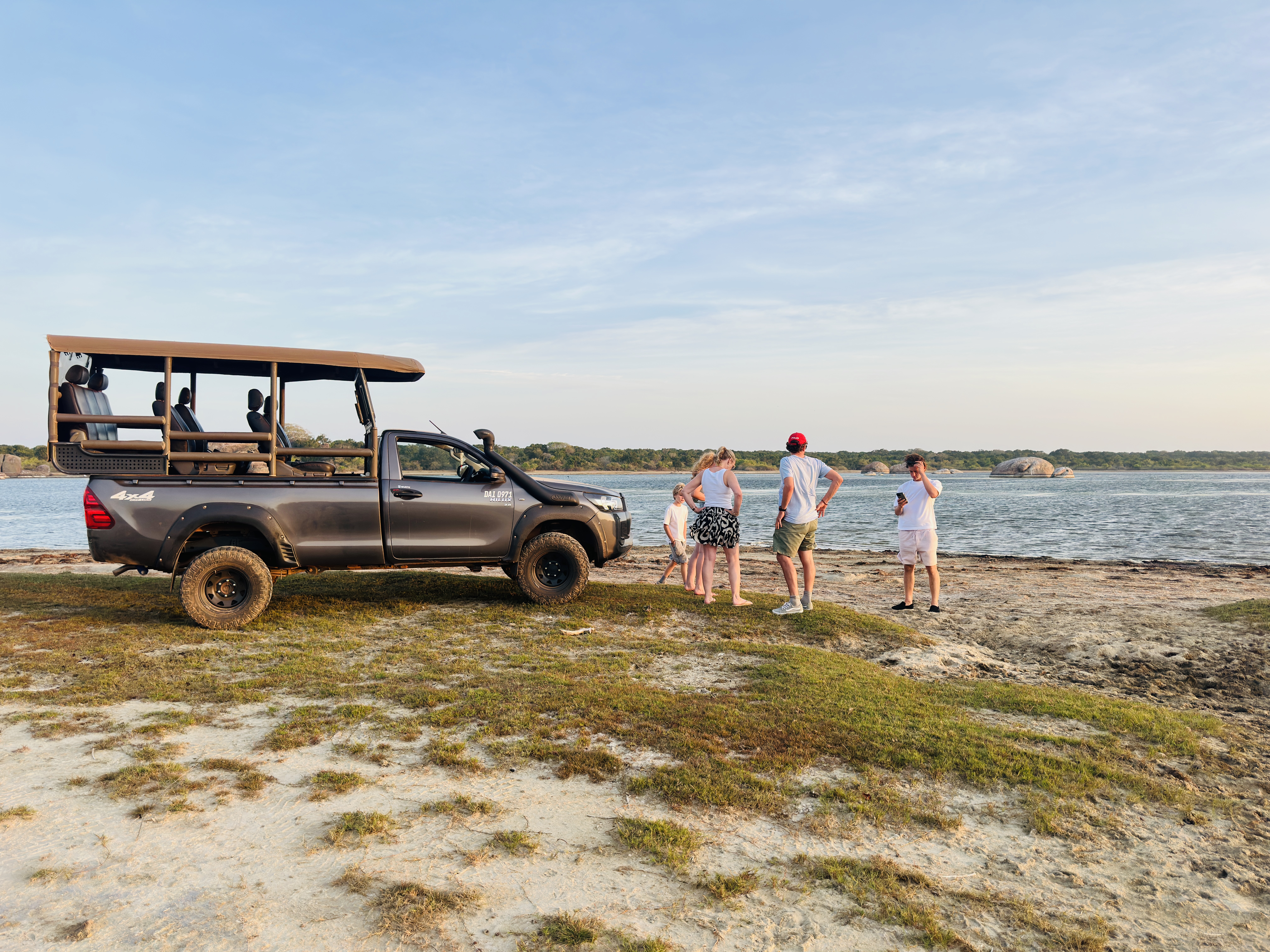 Safari jeep and guests beside a Yala lagoon